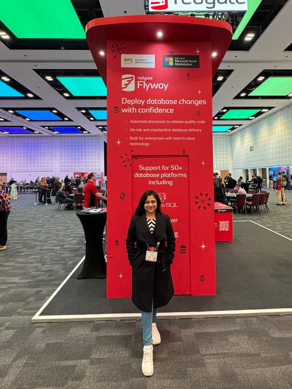 Diparati standing in front of the red Redgate Flyway stand at SQLBits 2026, in a conference hall.